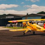 Festejos do 73º aniversário do Aeroclube de Canela no pátio do aeroclube com pessoas se divertindo, aviões chegando e saindo