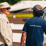 Festejos do 73º aniversário do Aeroclube de Canela no pátio do aeroclube com pessoas se divertindo, aviões chegando e saindo