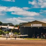 Festejos do 73º aniversário do Aeroclube de Canela no pátio do aeroclube com pessoas se divertindo, aviões chegando e saindo