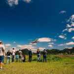 Festejos do 73º aniversário do Aeroclube de Canela no pátio do aeroclube com pessoas se divertindo, aviões chegando e saindo