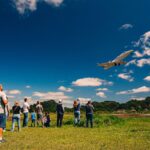 Festejos do 73º aniversário do Aeroclube de Canela no pátio do aeroclube com pessoas se divertindo, aviões chegando e saindo