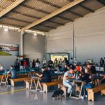 Festejos do 73º aniversário do Aeroclube de Canela no pátio do aeroclube com pessoas se divertindo, aviões chegando e saindo