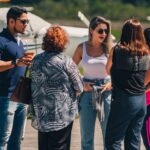 Festejos do 73º aniversário do Aeroclube de Canela no pátio do aeroclube com pessoas se divertindo, aviões chegando e saindo