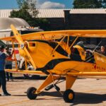 Festejos do 73º aniversário do Aeroclube de Canela no pátio do aeroclube com pessoas se divertindo, aviões chegando e saindo