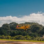 Festejos do 73º aniversário do Aeroclube de Canela no pátio do aeroclube com pessoas se divertindo, aviões chegando e saindo