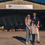 Festejos do 73º aniversário do Aeroclube de Canela no pátio do aeroclube com pessoas se divertindo, aviões chegando e saindo