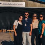 Festejos do 73º aniversário do Aeroclube de Canela no pátio do aeroclube com pessoas se divertindo, aviões chegando e saindo