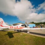 Festejos do 75º aniversário do Aeroclube de Canela no pátio do aeroclube com pessoas se divertindo, aviões chegando e saindo