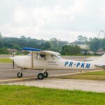 Festejos do 75º aniversário do Aeroclube de Canela no pátio do aeroclube com pessoas se divertindo, aviões chegando e saindo