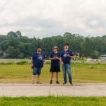 Festejos do 75º aniversário do Aeroclube de Canela no pátio do aeroclube com pessoas se divertindo, aviões chegando e saindo