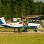 Festejos do 75º aniversário do Aeroclube de Canela no pátio do aeroclube com pessoas se divertindo, aviões chegando e saindo