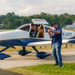 Festejos do 75º aniversário do Aeroclube de Canela no pátio do aeroclube com pessoas se divertindo, aviões chegando e saindo