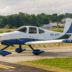 Festejos do 75º aniversário do Aeroclube de Canela no pátio do aeroclube com pessoas se divertindo, aviões chegando e saindo