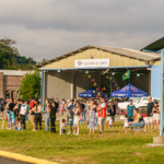 Festejos do 75º aniversário do Aeroclube de Canela no pátio do aeroclube com pessoas se divertindo, aviões chegando e saindo