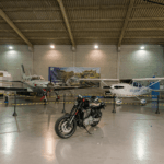 Festejos do 75º aniversário do Aeroclube de Canela no pátio do aeroclube com pessoas se divertindo, aviões chegando e saindo