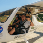 Festejos do 75º aniversário do Aeroclube de Canela no pátio do aeroclube com pessoas se divertindo, aviões chegando e saindo