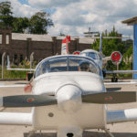 Festejos do 75º aniversário do Aeroclube de Canela no pátio do aeroclube com pessoas se divertindo, aviões chegando e saindo