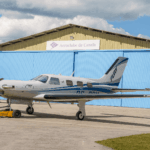 Festejos do 75º aniversário do Aeroclube de Canela no pátio do aeroclube com pessoas se divertindo, aviões chegando e saindo